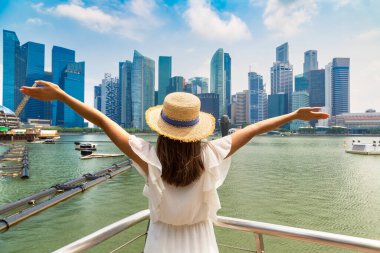 Güneşli bir günde güzel Singapur şehrine bakan bir kadın gezgin.
