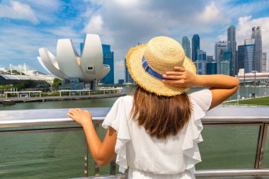 Singapur 'da güneşli bir günde Singapur' a bakan bir kadın gezgin.