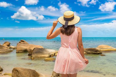 Tayland 'ın Koh Samui adasındaki Silver Beach' te pembe elbise ve hasır şapka giyen kadın gezgin.