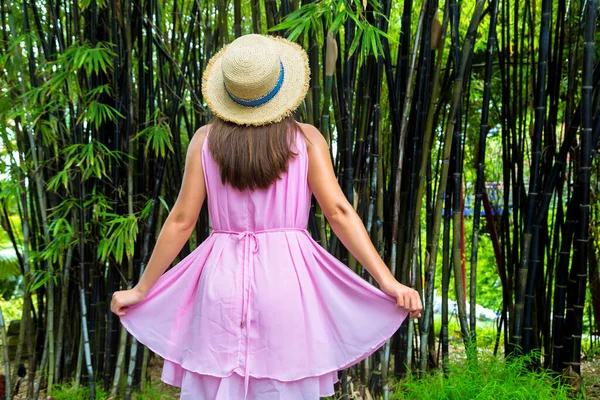 年轻美丽的女子正靠在大竹林边摆姿势 — 图库照片