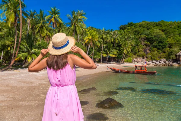 女性旅行者身に着けていますピンクドレスとわら帽子でトロピカルビーチ — ストック写真