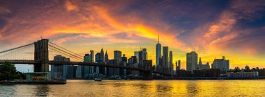 Brooklyn Köprüsü 'nün Sunset Manzarası ve New York City, ABD' deki Manhattan şehir merkezinin panoramik manzarası.