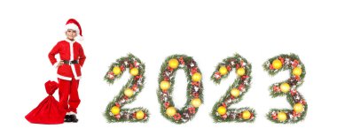 Çocuk Noel Baba 'nın elinde bir Noel çantası ve beyaz arka planda izole edilmiş noel ağacı dalları tarafından yapılan 2023 sayısı.