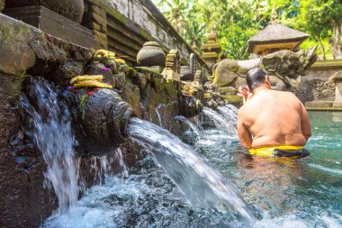 BALI, INDONEZYA - 28 Şubat 2020: Bali halkı Endonezya 'nın Bali kentindeki Pura Tirta Empul Tapınağı' ndaki kutsal havuzda dua ediyor