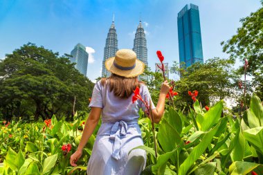 KUALA LUMPUR, MALAYSIA - 25 Şubat 2020: Kuala Lumpur, Malezya 'da güneşli bir günde Petronas Kulesi' nde kadın gezgin