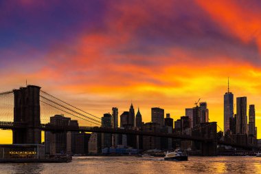 Brooklyn Köprüsü 'nün günbatımı ve New York City, ABD' deki Manhattan şehir merkezinin panoramik manzarası.