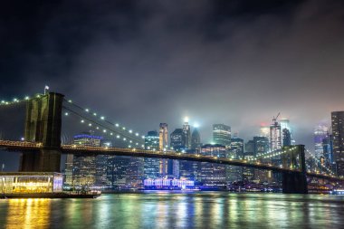 Brooklyn Köprüsü ve Manhattan şehir merkezinin panoramik gece görüntüsü New York City, ABD 'de gün batımından sonra