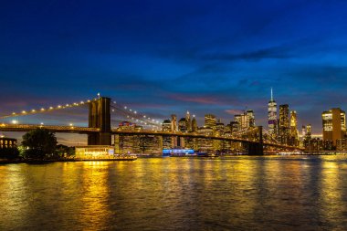 Brooklyn Köprüsü ve Manhattan şehir merkezinin panoramik gece görüntüsü New York City, ABD 'de gün batımından sonra