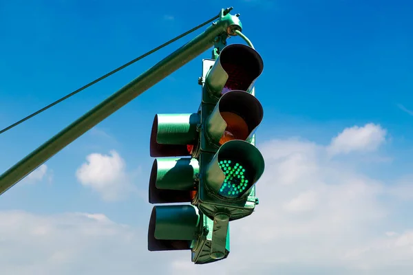 Green Traffic light on green against clear blue sky in New York City, NY, USA