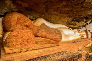 Unfinished reclining Buddha statue located on Pidurangala rock near Lion Rock in Sigiriya in a sunny day, Sri Lanka