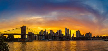 Brooklyn Köprüsü 'nün Sunset Manzarası ve New York City, ABD' deki Manhattan şehir merkezinin panoramik manzarası.