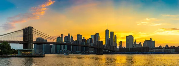 ブルックリン橋の夕日のパノラマとニューヨークのマンハッタンのダウンタウンのパノラマビュー — ストック写真