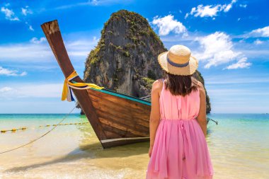 Tayland Phra Nang Sahili 'nde geleneksel uzun kuyruklu teknenin yanında güzel bir turist kadın.