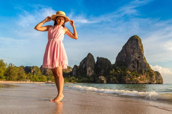 Tropikal Railay Sahili, Yengeç, Tayland 'da pembe elbise ve hasır şapka giyen güzel bir kadın.