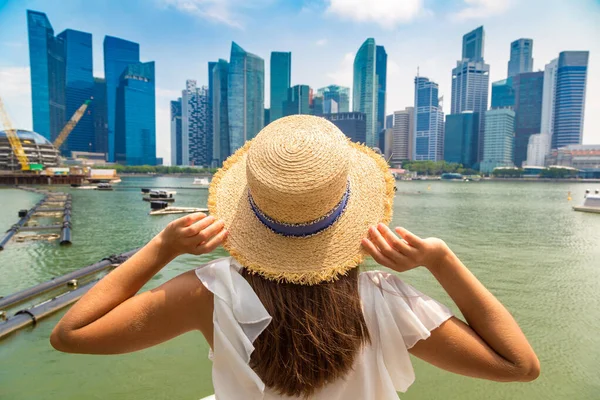 Güneşli bir günde güzel Singapur şehrine bakan bir kadın gezgin.