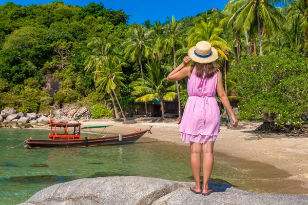 女性旅行者身に着けていますピンクドレスとわら帽子でトロピカルビーチ — ストック写真