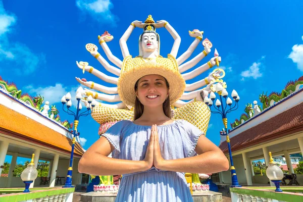 夏の日にタイ サムイ島のワット プライ ラム寺院のシヴァ像で青いドレスと藁帽子をかぶった女性旅行者 — ストック写真