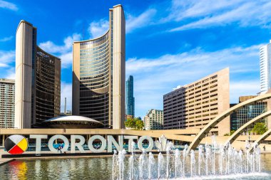 TORONTO, CANADA - 2 Nisan 2020: Toronto tabelası ve Toronto 'daki Nathan Phillips Meydanı' ndaki belediye binası güneşli bir günde, Ontario, Kanada