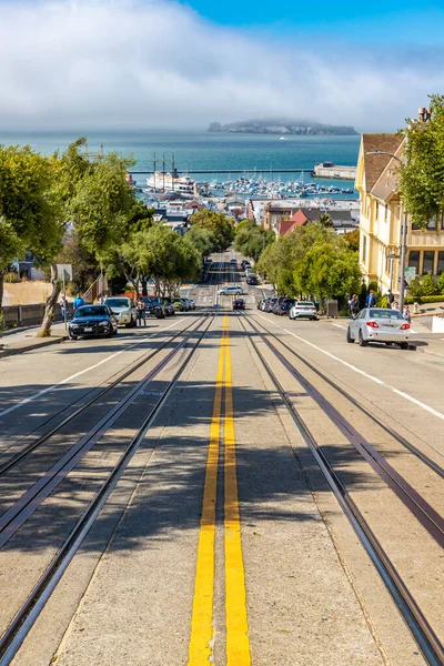 SAN FRANCISCO, ABD - 29 Mart 2020: The Cable car road and Alcatraz prison island on a background of San Francisco, California, ABD