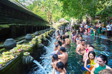 BALI, INDONEZYA - 28 Şubat 2020: Bali halkı Endonezya 'nın Bali kentindeki Pura Tirta Empul Tapınağı' ndaki kutsal havuzda dua ediyor