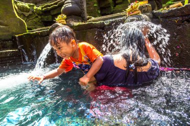 BALI, INDONEZYA - 28 Şubat 2020: Bali halkı Endonezya 'nın Bali kentindeki Pura Tirta Empul Tapınağı' ndaki kutsal havuzda dua ediyor