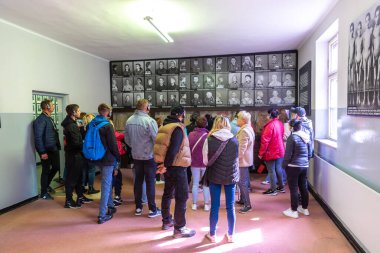 OSWIECIM, POLAND - 7 Eylül 2022: Güneşli bir günde Auschwitz toplama kampındaki fotoğraf sergisinde bir grup turist, Oswiecim, Polonya