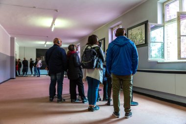 OSWIECIM, POLAND - 7 Eylül 2022: Güneşli bir günde Auschwitz toplama kampındaki fotoğraf sergisinde bir grup turist, Oswiecim, Polonya