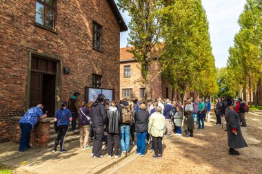 OSWIECIM, POLAND - 7 Eylül 2022: Güneşli bir günde Auschwitz Birkenau toplama kampında bir grup turist, Oswiecim, Polonya