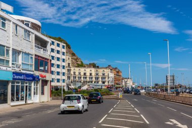 HASTINGS, BİRLİK KINGDOM - 25 Haziran 2022: Hastings, Sussex 'teki eski kasaba plajı boyunca bir yaz günü yol, Hastings, İngiltere