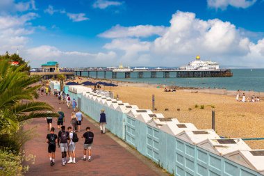 EASTBOURNE, İngiltere - 29 Haziran 2022: Güneşli bir yaz gününde Eastbourne plajı ve sahil kulübeleri, Doğu Sussex, İngiltere