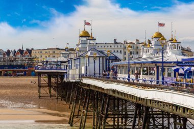 EASTBOURNE, UK - JUNE 29, 2022: Eastbourne pier and beach in a sunny summer day, East Sussex, England, UK clipart