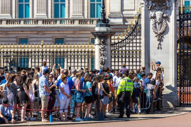 Londra - 17 Haziran 2022 Buckingham Sarayı 'nın dışındaki kalabalık güneşli bir yaz gününde Londra' da düzenlenen muhafız törenini izliyor.