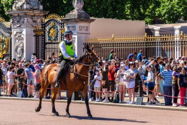 LONDON, İngiltere - 17 Haziran 2022: Londra 'da güneşli bir yaz günü Buckingham Sarayı' nın önünde düzenlenen koruma seremonisinin değişmesi için Metropolitan atlı polis devriyesi