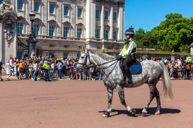 LONDON, İngiltere - 17 Haziran 2022: Londra 'da güneşli bir yaz günü Buckingham Sarayı' nın önünde düzenlenen koruma seremonisinin değişmesi için Metropolitan atlı polis devriyesi