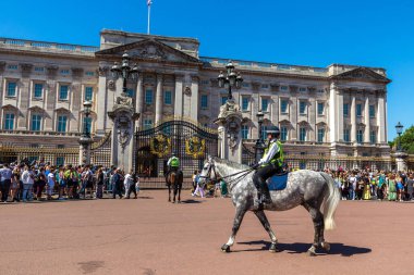 LONDON, İngiltere - 17 Haziran 2022: Londra 'da güneşli bir yaz günü Buckingham Sarayı' nın önünde düzenlenen koruma seremonisinin değişmesi için Metropolitan atlı polis devriyesi