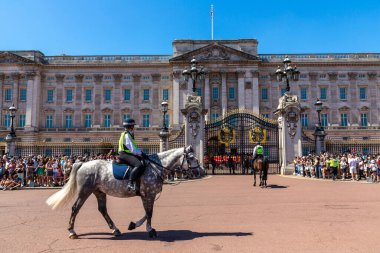 LONDON, İngiltere - 17 Haziran 2022: Londra 'da güneşli bir yaz günü Buckingham Sarayı' nın önünde düzenlenen koruma seremonisinin değişmesi için Metropolitan atlı polis devriyesi