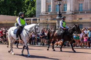 LONDON, İngiltere - 17 Haziran 2022: Londra 'da güneşli bir yaz günü Buckingham Sarayı' nın önünde düzenlenen koruma seremonisinin değişmesi için Metropolitan atlı polis devriyesi