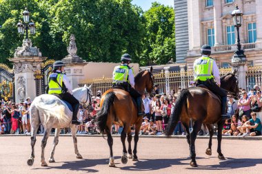 LONDON, İngiltere - 17 Haziran 2022: Londra 'da güneşli bir yaz günü Buckingham Sarayı' nın önünde düzenlenen koruma seremonisinin değişmesi için Metropolitan atlı polis devriyesi