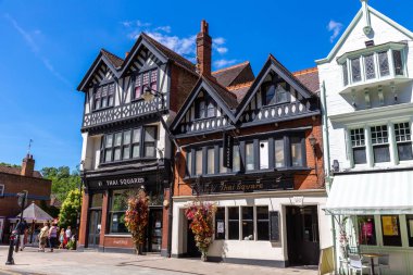 WINDSOR, İngiltere - 19 Haziran 2022: Popüler turist Windsor kasabasında güneşli bir yaz gününde geleneksel bir fachwerk binasının cephesi