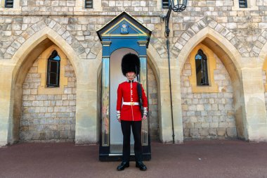 WINDSOR, İngiltere - 19 Haziran 2022 Windsor, İngiltere 'de güneşli bir yaz gününde Kraliyet Muhafızları Windsor Kalesi' nde görevdedir.