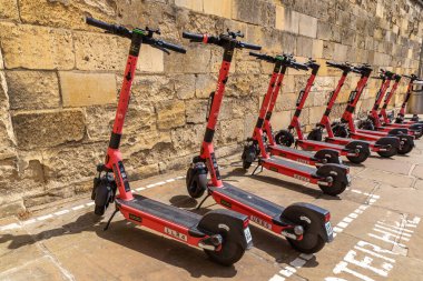 OXFORD, İngiltere - 11 Haziran 2022: Bir yaz günü Oxford 'da bir sokakta VOI şirketi tarafından kiralanan elektrikli scooterlar