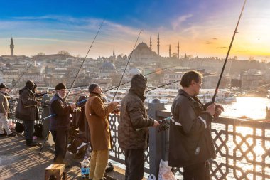 İSTANBUL, TURKEY - 10 Nisan 2022: Güneşli bir günde Türkiye 'nin İstanbul kentindeki Galata köprüsünde balıkçılar