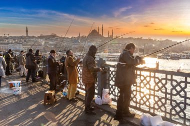 İSTANBUL, TURKEY - 10 Nisan 2022: Güneşli bir günde Türkiye 'nin İstanbul kentindeki Galata köprüsünde balıkçılar