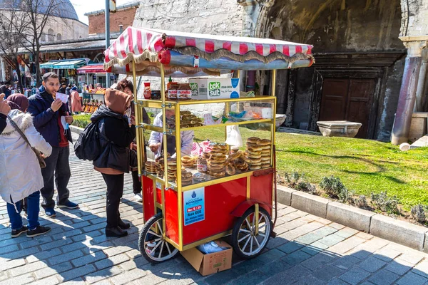 stock image ISTANBUL, TURKEY - APRIL 10, 2022: Street turkish vendor sells Simits - Traditional turkish bagels in Istanbul, Turkey in a sunny day