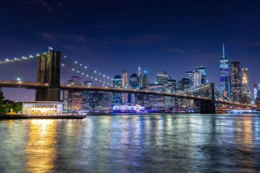 Brooklyn Köprüsü ve Manhattan şehir merkezinin panoramik gece görüntüsü New York City, ABD 'de gün batımından sonra