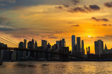 Brooklyn Köprüsü 'nün günbatımı ve New York City, ABD' deki Manhattan şehir merkezinin panoramik manzarası.