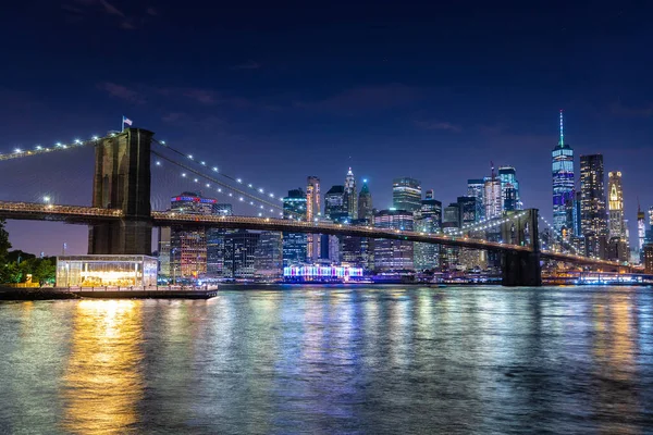ブルックリン橋とニューヨークの日没後のマンハッタンのダウンタウンのパノラマの夜景 — ストック写真