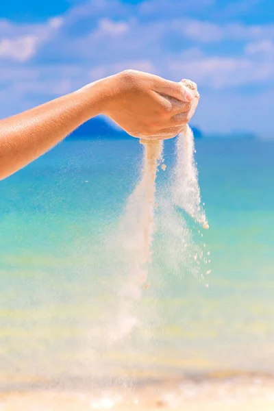 白い砂が女の手を通って熱帯のビーチに落ちる — ストック写真