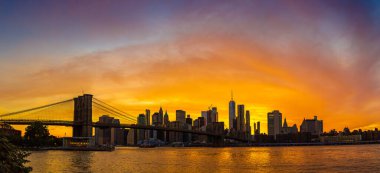 Brooklyn Köprüsü 'nün Sunset Manzarası ve New York City, ABD' deki Manhattan şehir merkezinin panoramik manzarası.