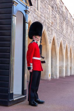 WINDSOR, İngiltere - 19 Haziran 2022 Windsor, İngiltere 'de güneşli bir yaz gününde Kraliyet Muhafızları Windsor Kalesi' nde görevdedir.